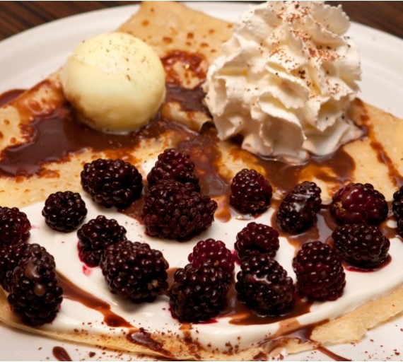Palačinka Crépes lehce plněná zakysanou smetanou a ostružinami, ovoněná  skořicí	s vanilkovou zmrzlinou a Ara čokoládou